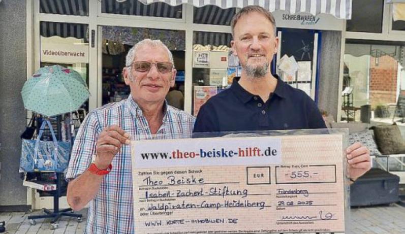 Manuel Korte uebergibt einen Scheck in Hoehe von 555 Euro an Theo Beiske